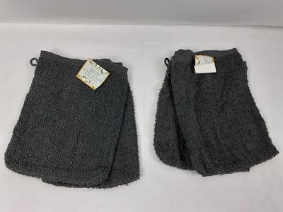 deux paires de chaussettes grises, encore étiquetées, posées sur une surface blanche