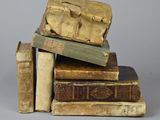 plusieurs vieux livres empilés les uns sur les autres sur une surface grise