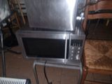 a microwave sitting on top of a table next to a chair