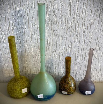 quatre vases de couleurs différentes posés sur une table