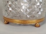 a glass bowl with a gold base on a table