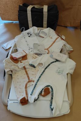 une valise remplie de vêtements pour bébé posée sur une table