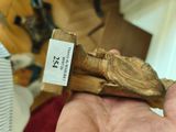 a hand holding a piece of wood with a label on it