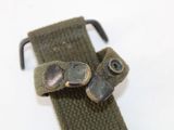 a green belt with two metal buttons on it
