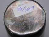 a silver pill case with a sticker on it