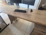 a desk with two computer monitors and a chair in front of it