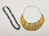 two necklaces and a bead necklace on a white surface