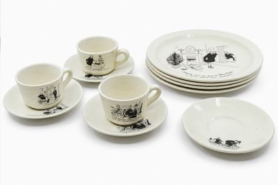 four cups and two saucers and a plate on the table