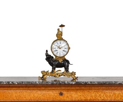 a clock on top of a table with a statue of a horse