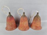 trois petites décorations en forme de cloche sont disposées les unes à côté des autres