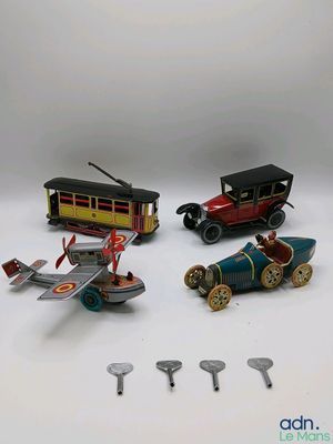 quatre petites voitures et un petit avion posés sur une surface blanche