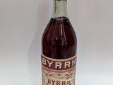 an old bottle of wine sitting on top of a white table