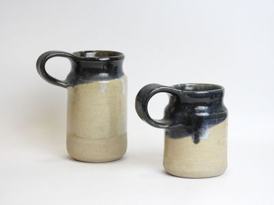 two black and white mugs sitting next to each other