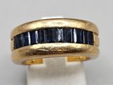 a close up of a gold ring with blue sapphires
