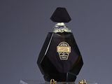 a bottle of perfume sitting on top of a suitcase