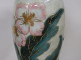 a vase with a flower painted on it sitting on a table
