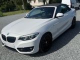 une photo d'une BMW décapotable blanche garée sur un parking