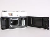 an old camera with a black case open on a white surface