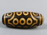 a close up of a black and white bead on a gray surface