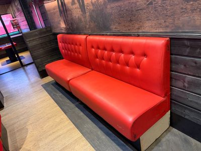 un banc rouge dans un coin d'un restaurant