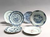 several blue and white plates with designs on them sitting on a table