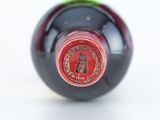 a close up of a bottle of wine on a white surface