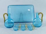 a blue glass table set with blue vases and glasses