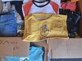 une boîte en carton remplie de vêtements de bébé et un ours en peluche