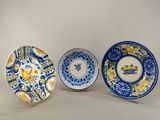 trois assiettes bleues et blanches ornées de fleurs jaunes