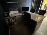 a desk with two computer monitors and a book shelf