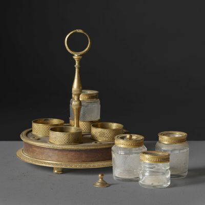 un plateau en or sur lequel sont posés un bocal en verre et un bougeoir