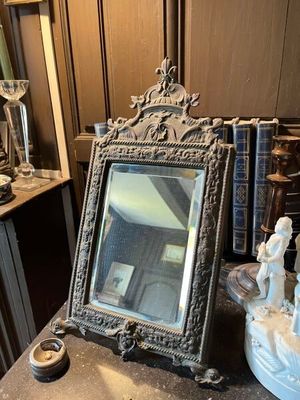 un miroir et une statue posés sur une table dans une pièce
