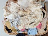 a wicker basket filled with clothes and a teddy bear