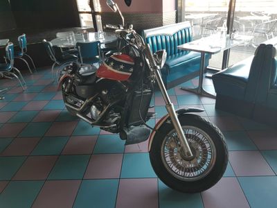 a motorcycle that is sitting in a room with a blue couch