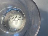 a glass cup with a writing on it sitting on a table