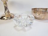 un bol en verre et une assiette en argent posés sur une table