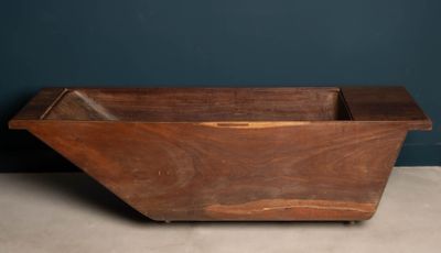 an old wooden box sitting on top of a floor next to a blue wall