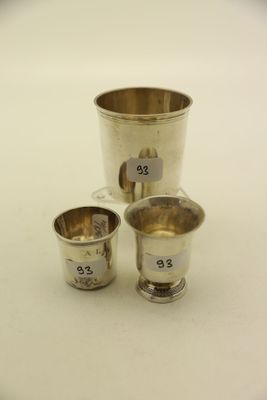 trois coupes en argent portant des chiffres, posées sur une surface blanche