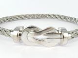 un gros plan d'un bracelet en argent orné d'un nœud