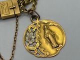 a gold necklace with a coin and a lock on it