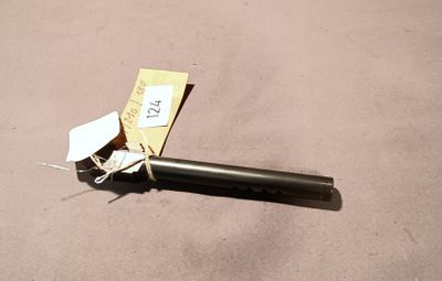 a black pipe with a tag on it laying on the ground