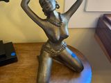 a statue of a woman sitting on a table next to a horse
