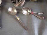 a lot of spoons and spoon knives on a table
