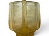 a yellow glass vase with a handle on a white background