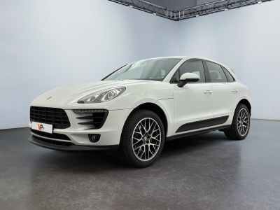 Une Porsche Cayén blanche est garée dans une pièce blanche.