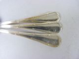three silver spoons with handles on a white surface