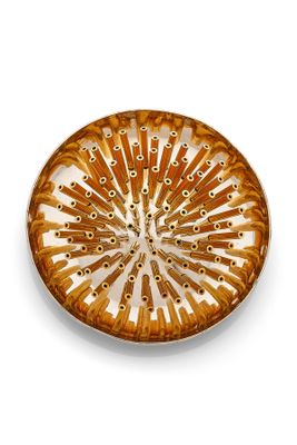 a brown and white plate on a white surface