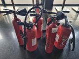 several fire extinguisors are lined up on a table