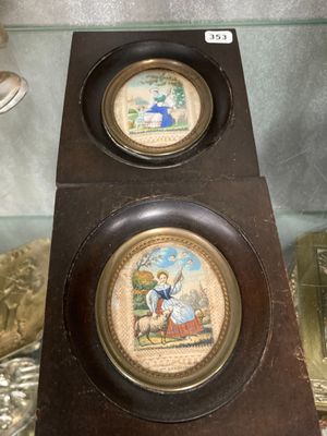 une horloge sur laquelle figurent deux images, dans une vitrine en verre