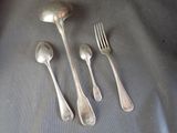 five silver spoons and a fork on a table